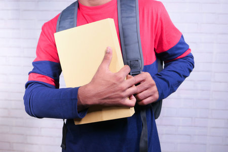 young boy hand holding stack of books on white background