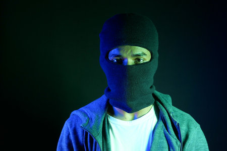 Thief in a mask on black background close up,の写真素材