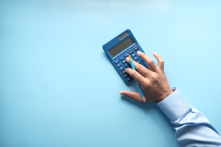 top view of accountant using calculator on blue backgroundの写真素材