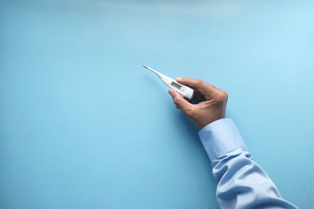 close up of man hand holding digital thermometer.
