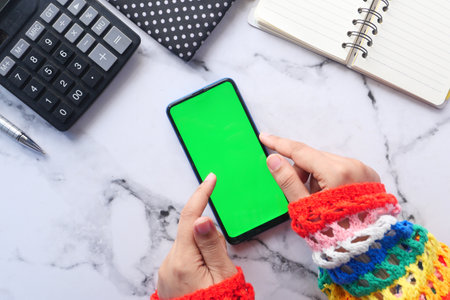 top view of women hand using smart phone with stationary on tableの写真素材