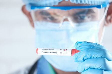 laboratory technician hand holding blood test tubeの写真素材