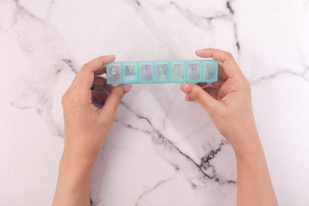 Top view of senior hands taking medicine from a pill boxの写真素材