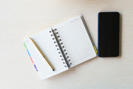 top view of smart phone and notepad on tableの写真素材