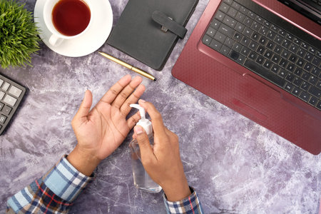 businessman using sanitizer gel on on office desk