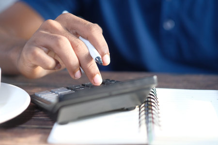 Close up of man hand using calculator