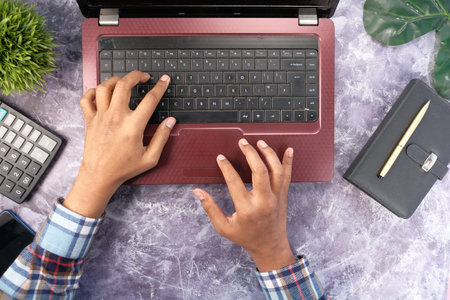 top view of man hand typing on laptop on table