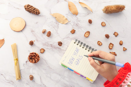 women hand writing new year goals on paper