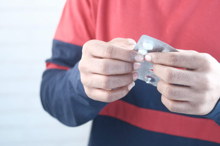 Close up of hand holding blister packs .