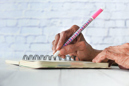 Close up of senior women hand writing on notepad