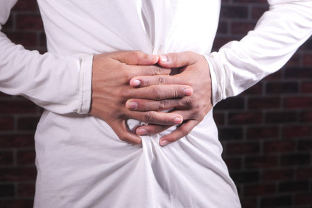 young man suffering stomach pain close up.