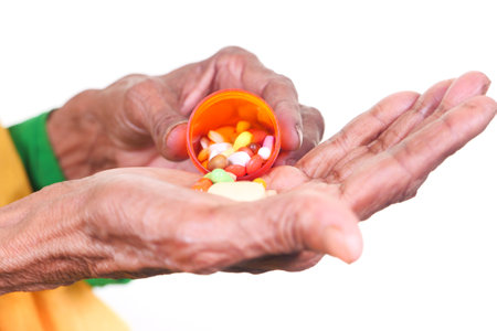 senior women hands taking medicine isolated on whiteの写真素材