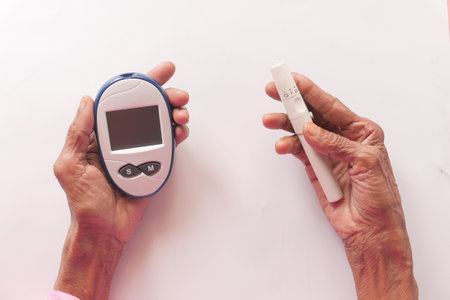 Senior women diabetic measure glucose level at homeの写真素材