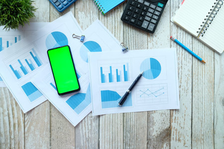 financial graph, smart phone calculator and notepad on table