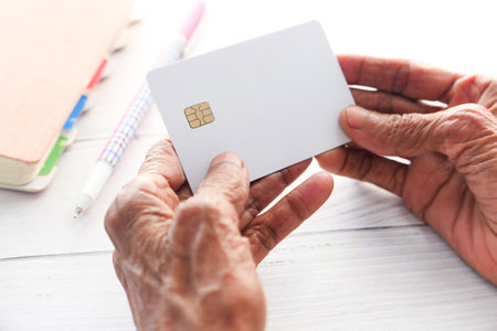 senior women hand holding credit cards reading informationの写真素材