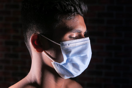 side view of man closed his eye with protective face mask isolated on black