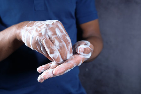 young man washing hands with soap warm waterの写真素材