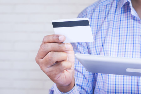 Man hand holding credit card and using digital tablet shopping onlineの写真素材