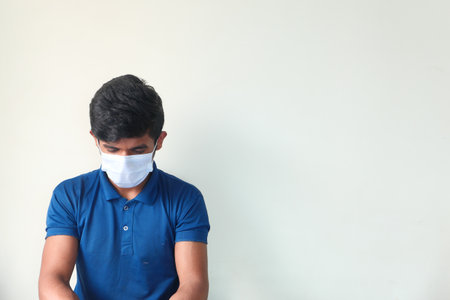 A young man with protective mask against a wallの写真素材