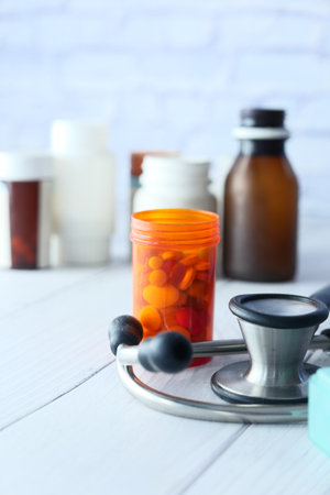 stethoscope and pills container on wooden backgroundの写真素材