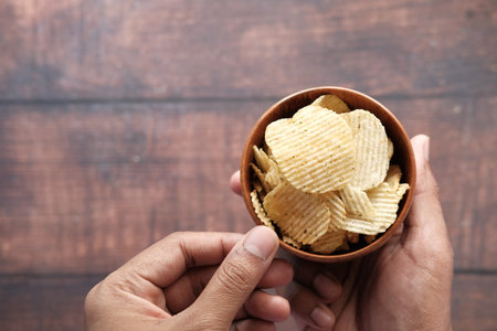 top view of man hand eating potato wedges.の写真素材