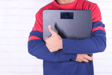young man holding weight machine doing thumbs up sign
