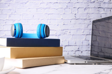 stack of books , laptop and clock on table close upの写真素材