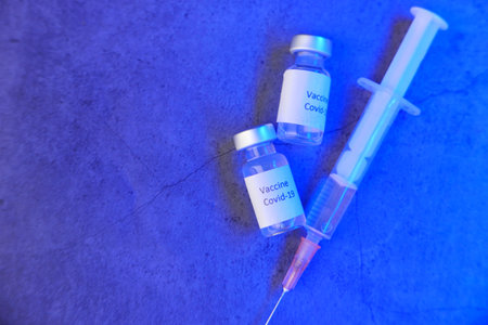 Close up of coronavirus vaccine and syringe on black backgroundの写真素材