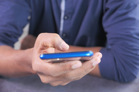 Close up of young man hand using smart phone.の写真素材
