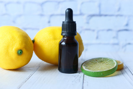 Close up of a bottle of oil and lemon on table with copy space .