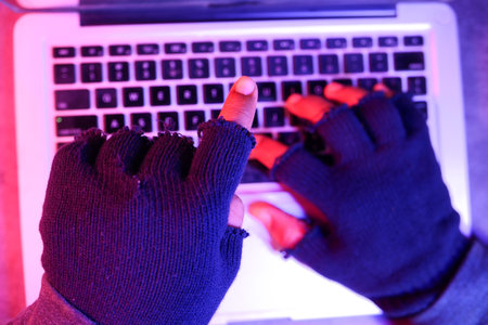 hacker hand stealing data from laptop top down.の写真素材