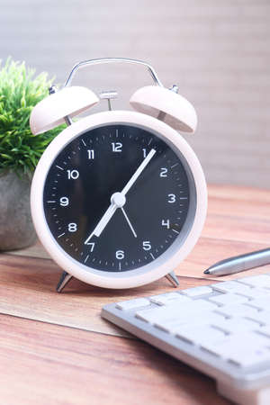 stack of books , laptop and clock on table close upの写真素材