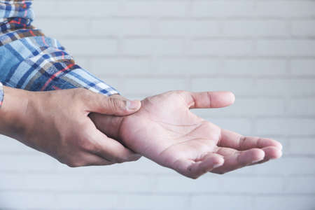 man suffering pain in hand close upの写真素材