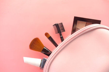 top view of decorative black color cosmetic on pink background