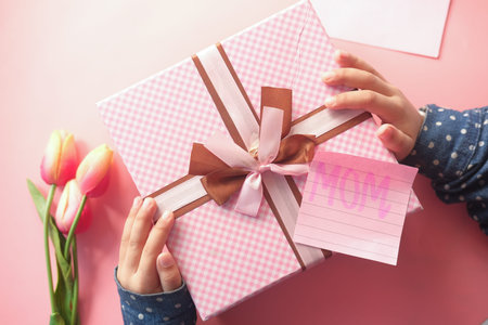 mother day concept of child hand holding pink color gift boxの写真素材