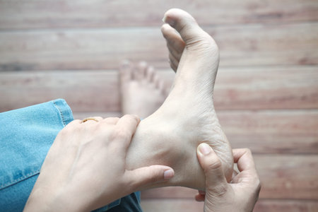 women feet and hand massage on injury spot.