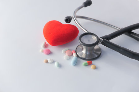 heart shape symbol and pills on white backgroundの写真素材