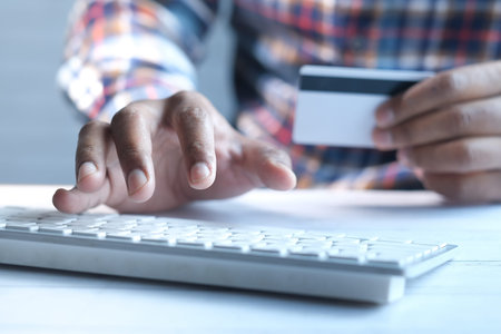 man hands holding credit card and using laptop shopping online