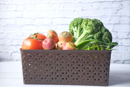 Healthy food selection with fresh vegetables in a bowl on tableの写真素材