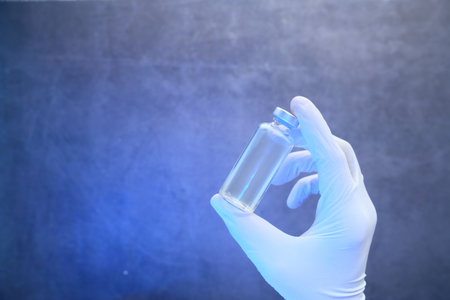 hand in latex gloves holding coronavirus vaccine, with copy spaceの写真素材