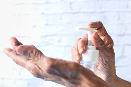 close up of senior women hand using sanitizer gel for preventing virusの写真素材