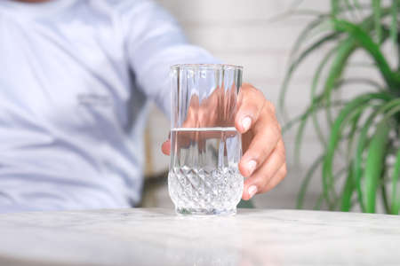 hand holding a glass of water against white backgroundの写真素材