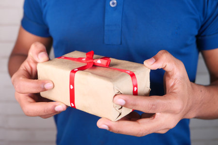 unrecognized mans hand holding a gift box with copy space