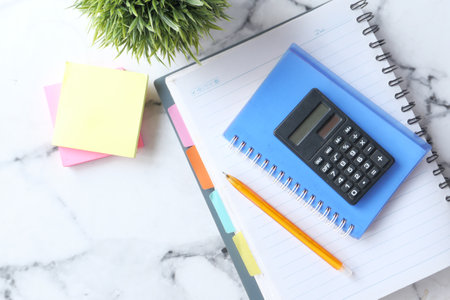 calculator and notepad on tiles background top downの写真素材