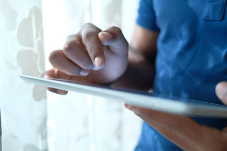 man hand using digital tablet on black background