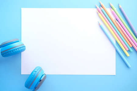 top view of colorful pencils on empty paper on blue backgroundの写真素材