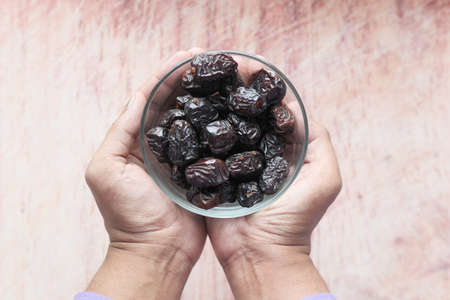 close up of fresh date fruit in a bowl on tableの写真素材