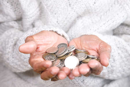 saving coin concept with many coins on senior women handの写真素材