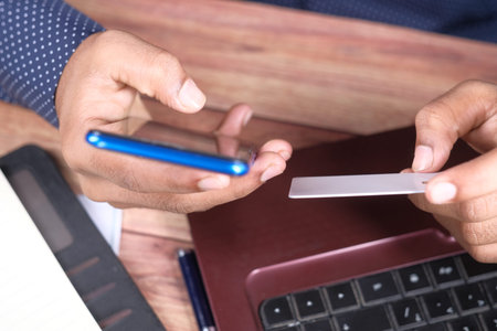 man hands holding credit card and using smart phone shopping online
