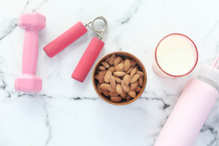 Diet plan with almond nut, dumbbells, banana on table .